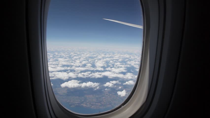Clouds seen through the window of jet airplane. Airplane flies above the weather Royalty-Free Stock Footage #1282480