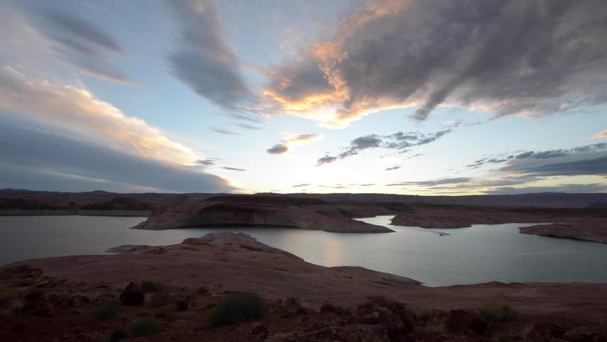 single boat cutting smooth surface of lake Powell after sunset tripod steady 