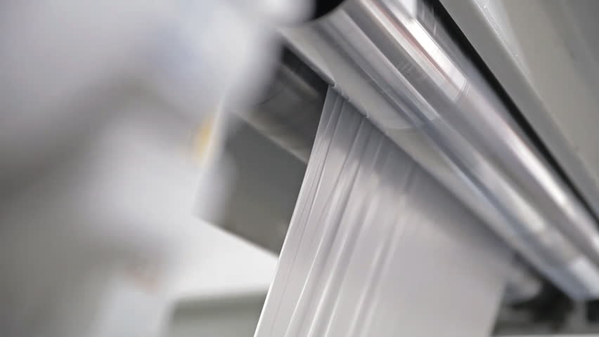 Video shows a factory, producing plastic bags. Shafts are rotating. Cellophane is moving between the shafts. | Shutterstock HD Video #12836057