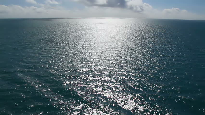 The sun glistens on the ocean on a warm summer day.  