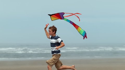 Cinemagraph - Boy running with kite at beach, slow motion. Looping Motion Photo.  Stock Video