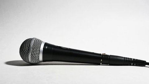 Microphone Being Picked Up by Man Isolated on White in Slow Motion