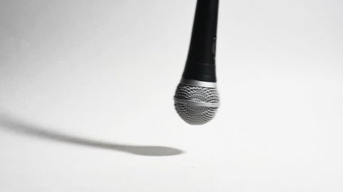 Microphone Swinging Falling and Dropped Isolated on White in Slow Motion