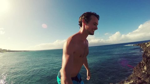 POV Slow Motion Cliff Jumping Backflip. Athletic Young Man Jumping From Cliff Into Ocean. Adventure Extreme Sports Lifestyle Hobby Vacation