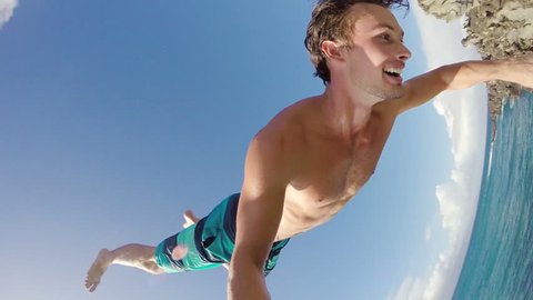 POV Slow Motion Cliff Jumping Backflip. Athletic Young Man Jumping From Cliff Into Ocean. Adventure Extreme Sports Lifestyle Hobby Vacation