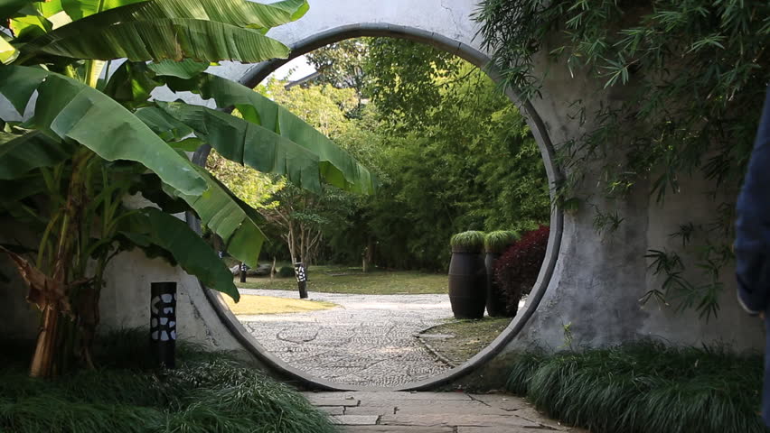 Wuzhen,China_Nov.06, 2015 : Asian woman walking through the round gate of the beautiful oriental garden in Wuzhen, China