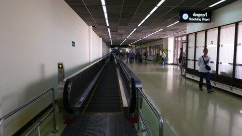 BANGKOK - MARCH 30, 2015: POV slide on travellator, old international airport, alert announce sound 'watch your step'. Don Mueang airport, located at Bangkok city. Rather empty departure terminal area