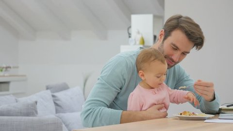 Man working from home and feeding baby