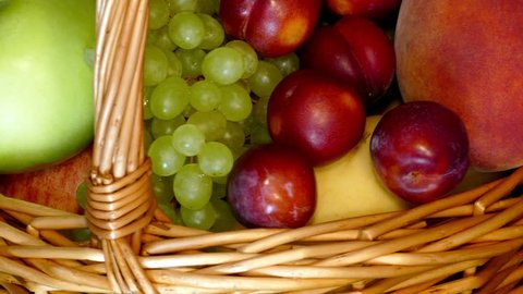 Basket full of ripe garden fruit – pears, apples, grapes, plums rotating, front shot, extreme close up, loop (ultra hd 3840x2160) Video de stock