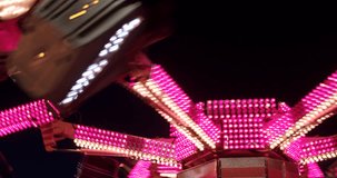 Carnival ride at night spinning with pink lights