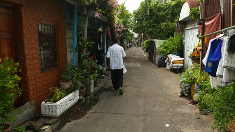 BANGKOK - MARCH 28, 2015: First person view camera walk along tiny alley, Sao Chingcha subdistrict, Phra Nakhon district of Bangkok city. Few unidentified people on way, men come into the building
