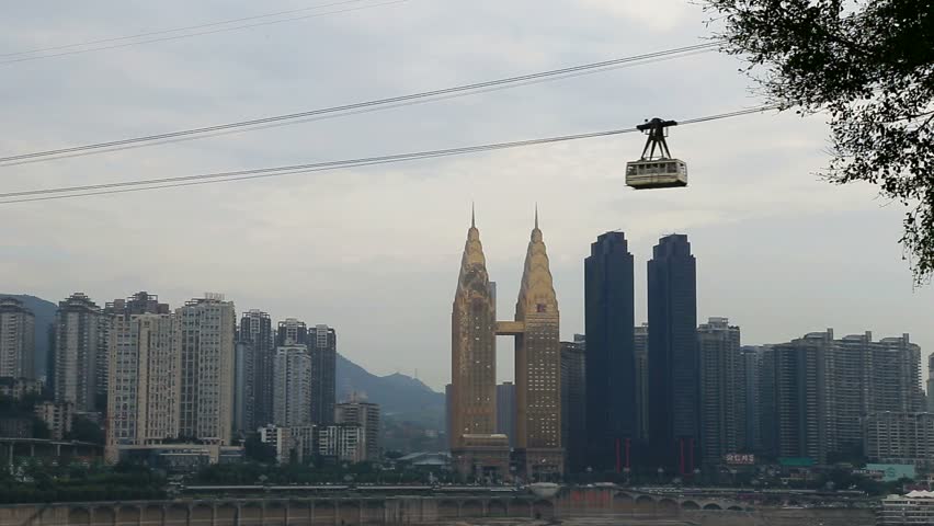 A cable car crossing changjiang river with the background of skyscrapers in Chongqing City of China
