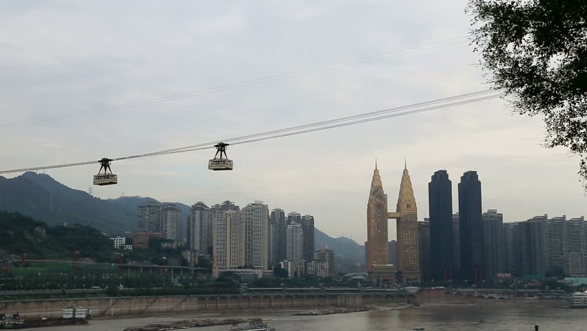 two cable cars crossing changjiang river with the background of skyscrapers in Chongqing City of China