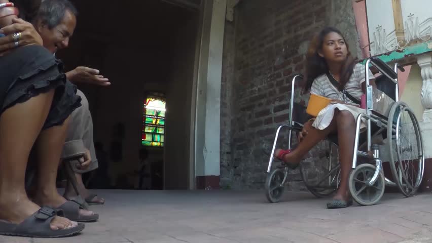 SAN PABLO CITY, LAGUNA, PHILIPPINES - NOVEMBER 21, 2015: A disabled young lady in wheelchair begs at church portal. | Shutterstock HD Video #12910322