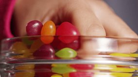 4K Close up of a child's hand taking a handful of candy from a sweet jar - Powered by Shutterstock - Get 15% off with code: PIKWIZARD15