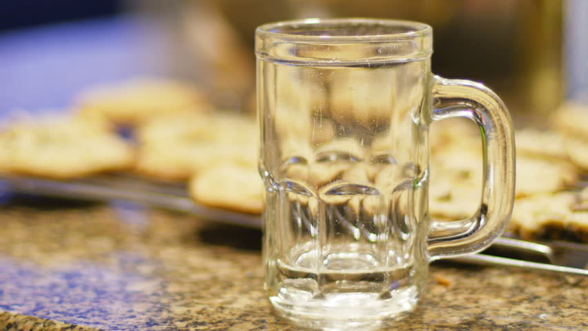 Milk and Warm Chocolate Chip Cookies Being Eaten