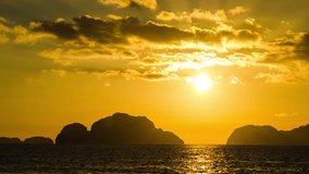 Beautiful sunset timelapse over the Indian ocean with clouds and rocky islands on the background in El Nido, Philippines