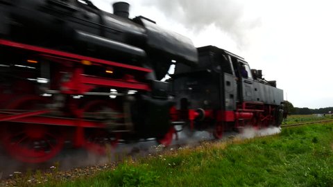 BEEKBERGEN, THE NETHERLANDS - SEPTEMBER 6: Old steam locomotive pulling railroad passenger cars in the countryside.