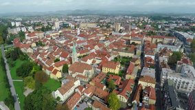 In this video, we can see an old town in the city with the church in the middle. There is also a river flowing by. Wide-angle shot taken from the sky down.