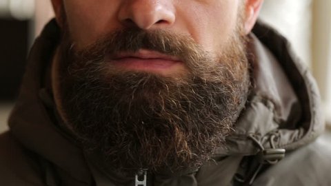 Close up of a bearded man smoking electronic cigarette