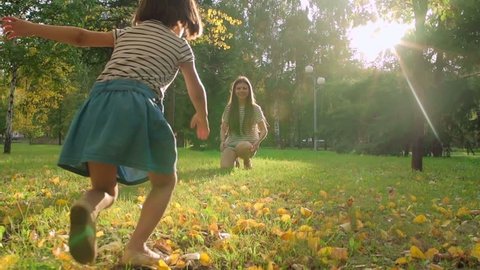 Little girl running to hug her lovely mom in the park