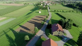 In this video, we can see a beautiful summer day in the country side. Wide-angle shot taken from the above. trees and the country road together with a few houses seen in this video. 