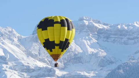 black and yellow balloon with the snowy mountain at the back : vidéo de stock