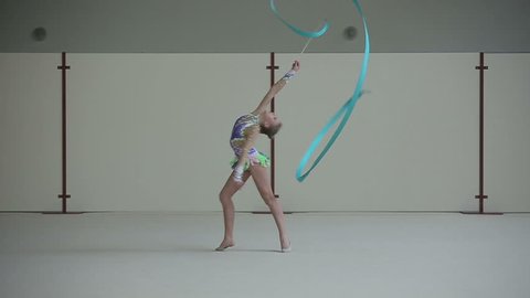 Rhythmic gymnastics: Girl training a gymnastics exercise with a ribbon. Slow motion
