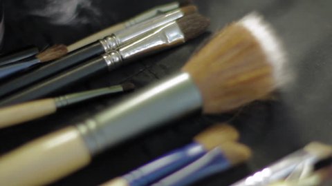 Close up of makeup brushes on a table.
