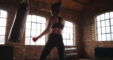 Beautiful Kickboxing woman training punching bag in fitness studio fierce strength fit body Slow Motion