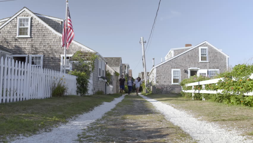 Multiethnic Teens Hold Hands And Run Down Shell Road In Picturesque New England Seaside Village