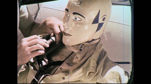 UNITED STATES 1960s – Mechanics place crash test dummy into car.