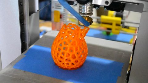 3D printer prints shape orange close-up