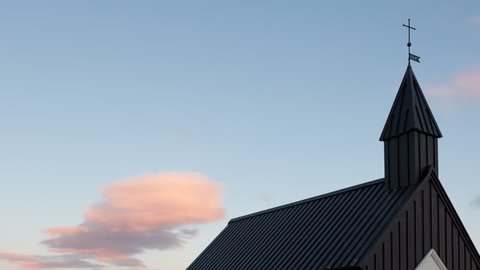 4K Timelapse zoom out of the black wooden church in Budir, Iceland at sunset in wide angle view with clouds passing by