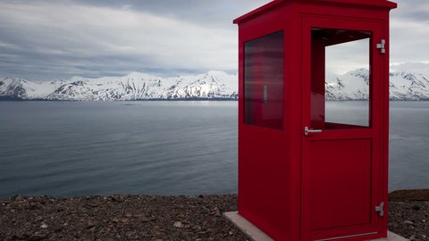 4K Timelapse zoom out of a red phone booth in the middle of nowhere with snow covered mountains in the background in Iceland