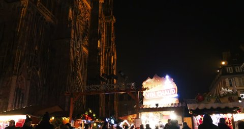 STRASBOURG, FRANCE - CIRCA 2015: Tourists drinking Gluhwein (Hot-spiced Wine) at Christkindlesmarkt Christmas Market in Strasbourg, Place de la Cathedrale  and tilt-up to Cathedral Notre-Dame
