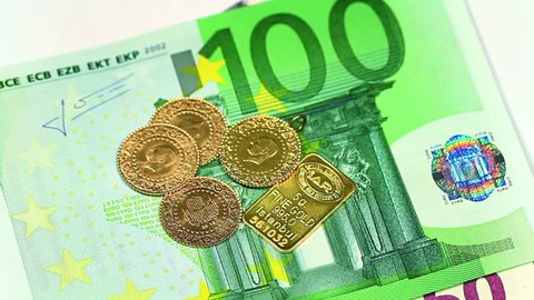 Euro banknote and Gold coins with a goldbar falling on. Closeup of European banknot with gold coins. Perfect for any financial, commerce, treasury or banking video needs. 
