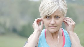 Senior woman exercising with earphones on