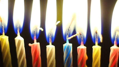 Birthday candles slowly burning down. Extreme macro clip.