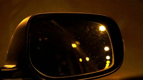 Automotive: Tunnel lights on side mirror of a car at night