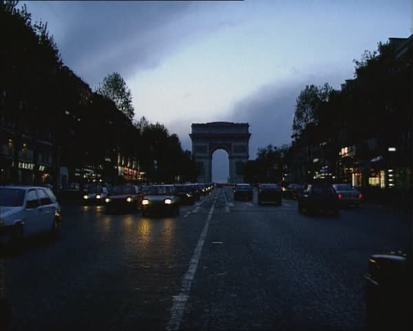 PARIS 1980s: twilight traffic Avenue des Champs d Elysees with Arc de Triomphe  in background. Royalty-Free Stock Footage #13006346