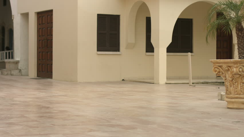 Young woman wearing dress and hat carries luggage to hotel, walks around city