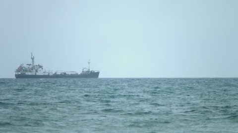 Multi-purpose vessel carrying bulk cargo on deck across sea. Shipping services