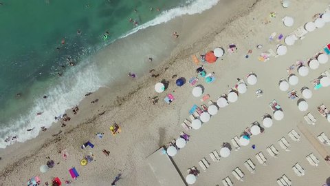 ALANIA - AUG 16, 2015: People swim in sea near beach with sunbeds and parasols at summer sunny day. Aerial view Editorial Stock Video