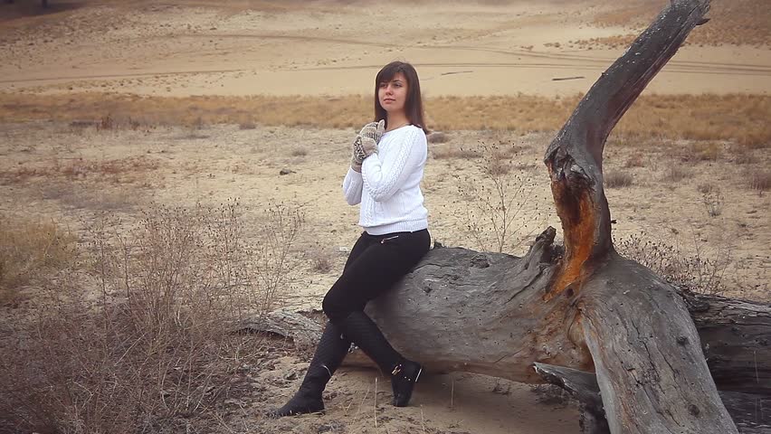 girl  woman in a sweater and mittens on the nature autumn cold dry wood tree