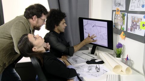 Three architects discussing projects at work in office