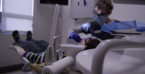 Dental professionals working on patients in a modern dentist's chair