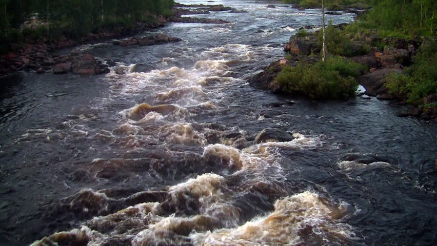 rough river flows through the forest. Scandinavia, loop