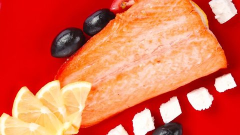 roast salmon fish meat fillet with lemon black greek olives white goat cheese on red plate 1920x1080 intro motion slow hidef hd