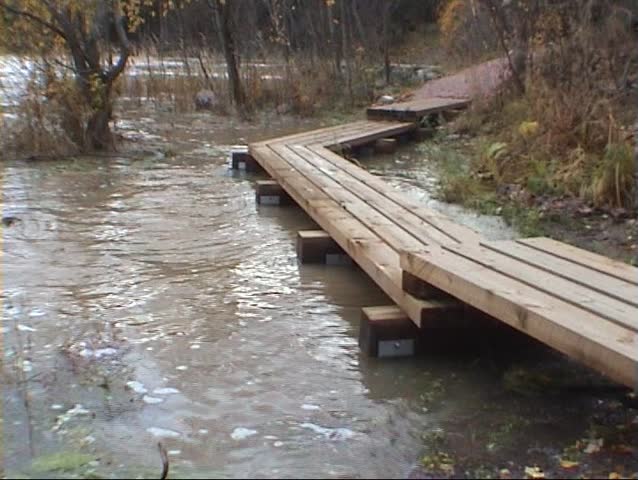Wooden path covered by flooded river